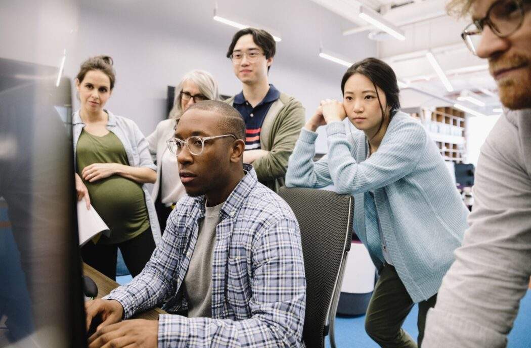 People standing around computer