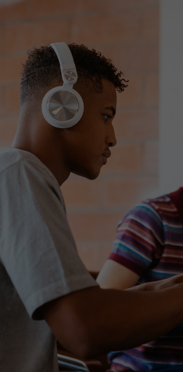 Two boys looking at their laptops